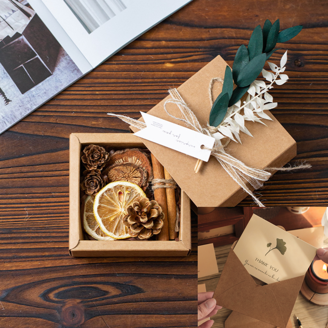 Handcrafted gift box with dried flowers, cinnamon, and a thank you note on a wooden table.